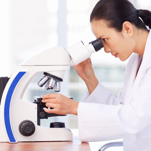 Lab technician using microscope